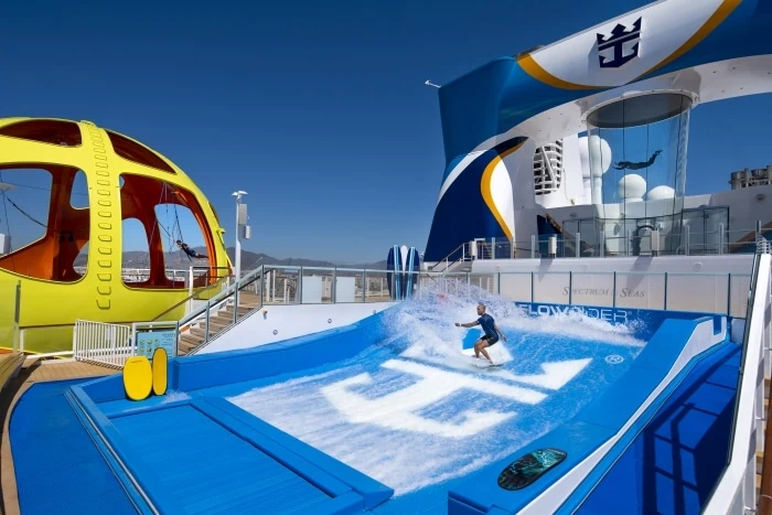 Homme surfant sur Royal Caribbean FlowRider sur le bateau de croisière Spectrum of the Seas