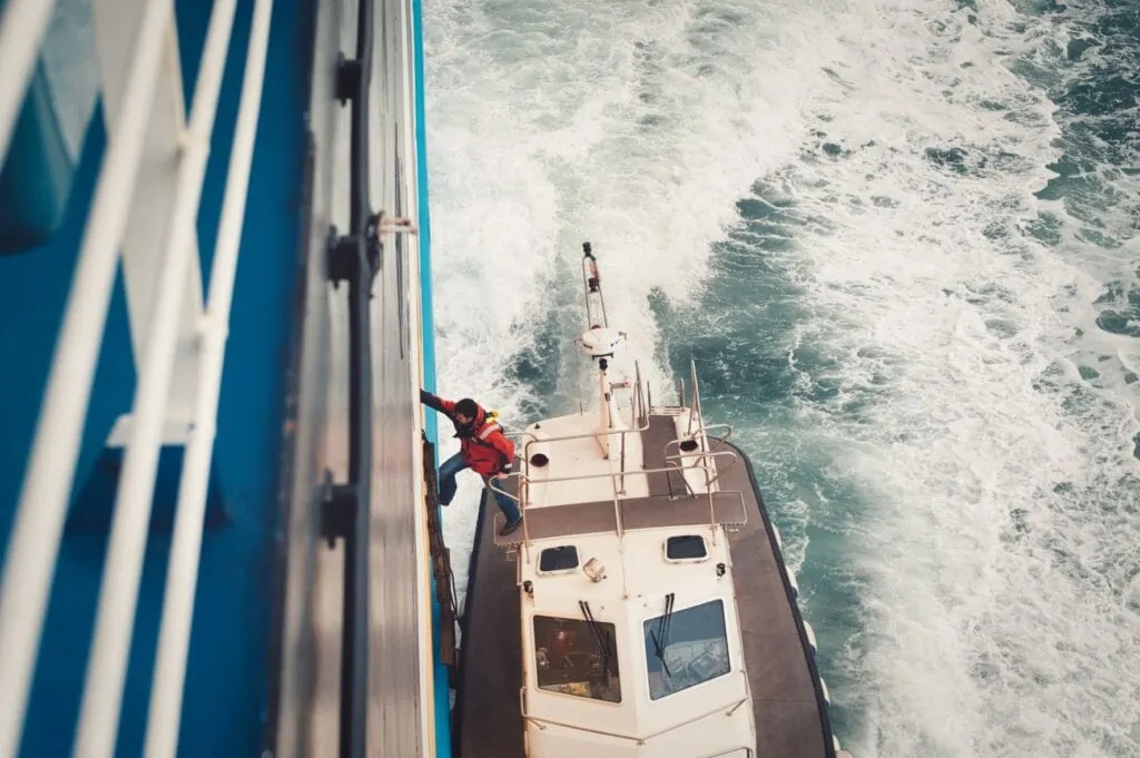 Un pilote monte du bateau-pilote à l'échelle du navire de croisière