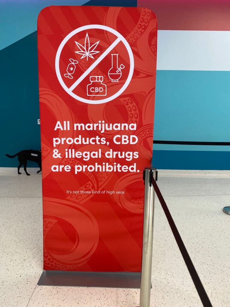 Un panneau au terminal de croisière Virgin Voyages à Miami affichant un avertissement indiquant que tous les produits à base de marijuana, le CBD et les drogues illégales sont interdits sur leurs navires de croisière.