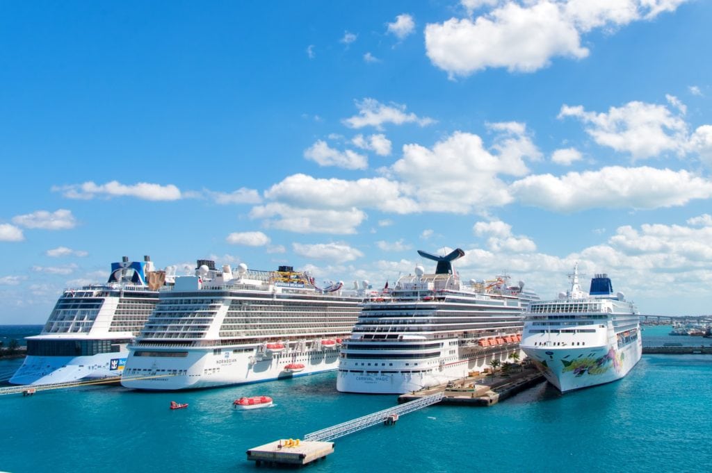 Grands navires de croisière des compagnies de croisière Carnival, Norwegian et Royal Caribbean amarrés au port de Nassau, aux Bahamas, sur fond d'eau de mer et de ciel nuageux