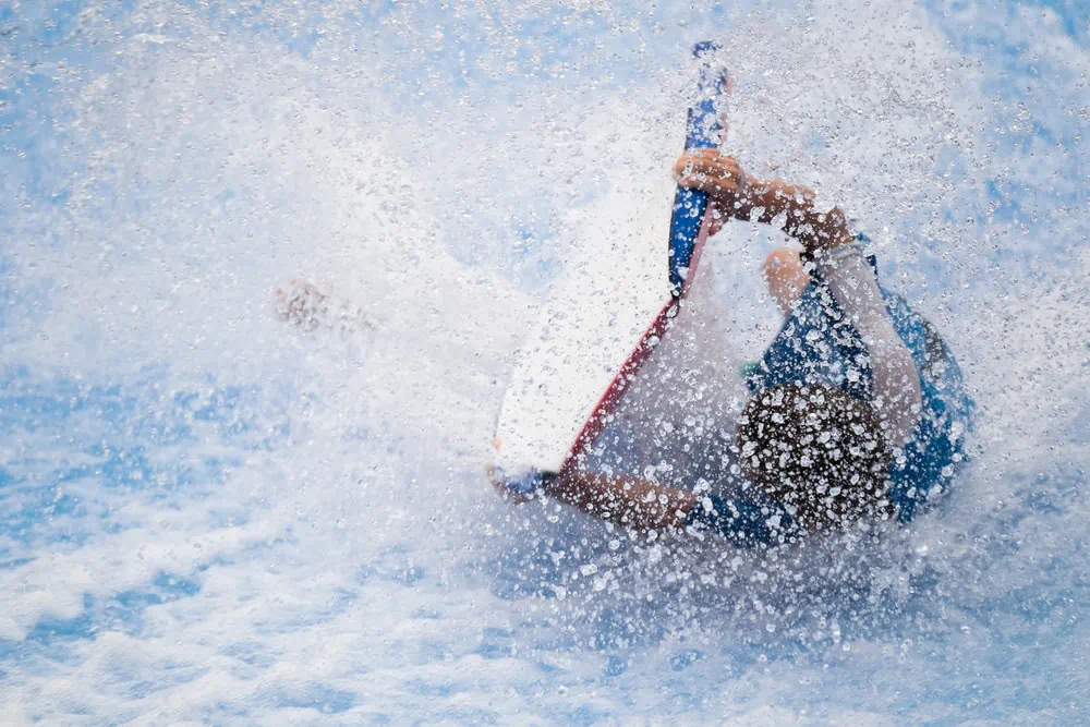 Homme tombant d'une planche de surf sur FlowRider