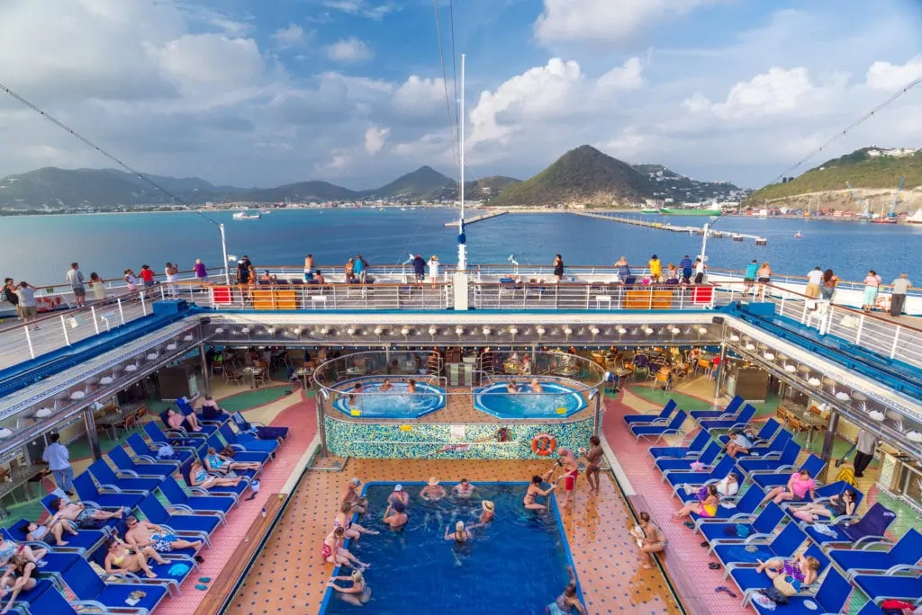 Passagers se détendant sur la terrasse d'une piscine d'un bateau de croisière au départ de Saint-Martin