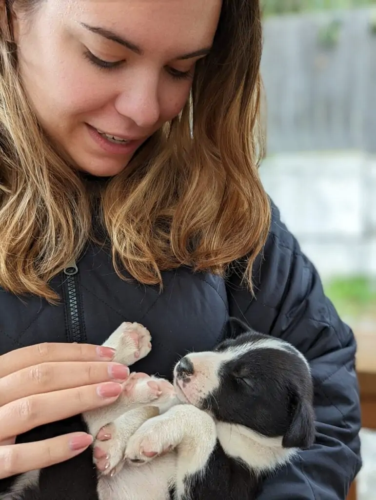 Victoria avec un chiot de 8 semaines au camp de traîneau à chiens