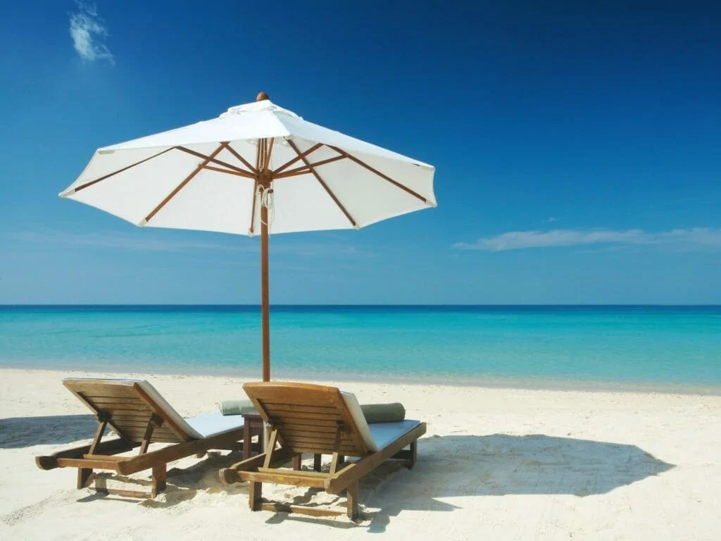 Vue de deux chaises et parasol blanc sur la plage