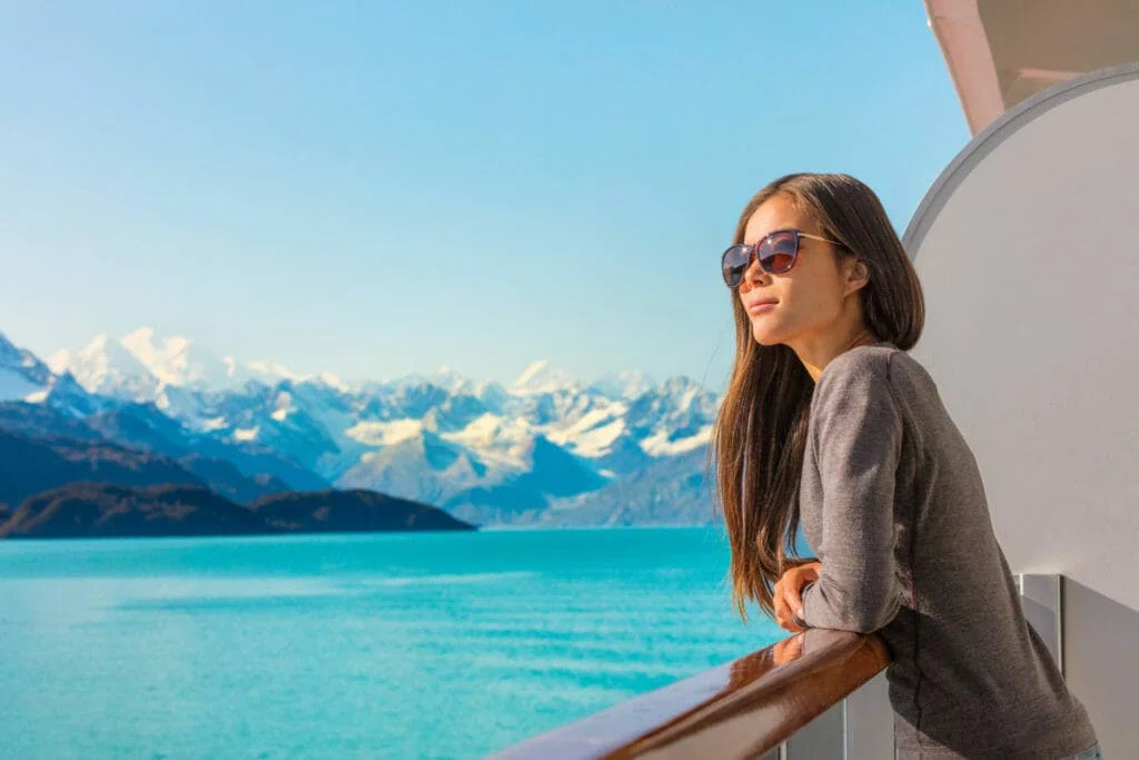 Femme naviguant sur un bateau de croisière de l'Alaska avec vue sur les montagnes et le paysage