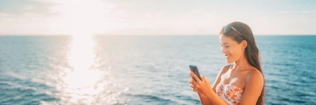 Femme sur son téléphone utilisant les forfaits Internet Norwegian Cruise Line