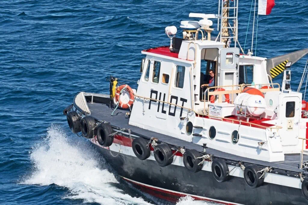 un bateau-pilote sort à la rencontre du bateau de croisière Seabourn Quest à l'entrée du port de St. Johns.