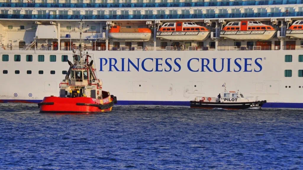 bateau de croisière EMERALD PRINCESS de la compagnie PRINCESS CRUISES, au départ du port du Pirée, escorté par un remorqueur et un pilote.