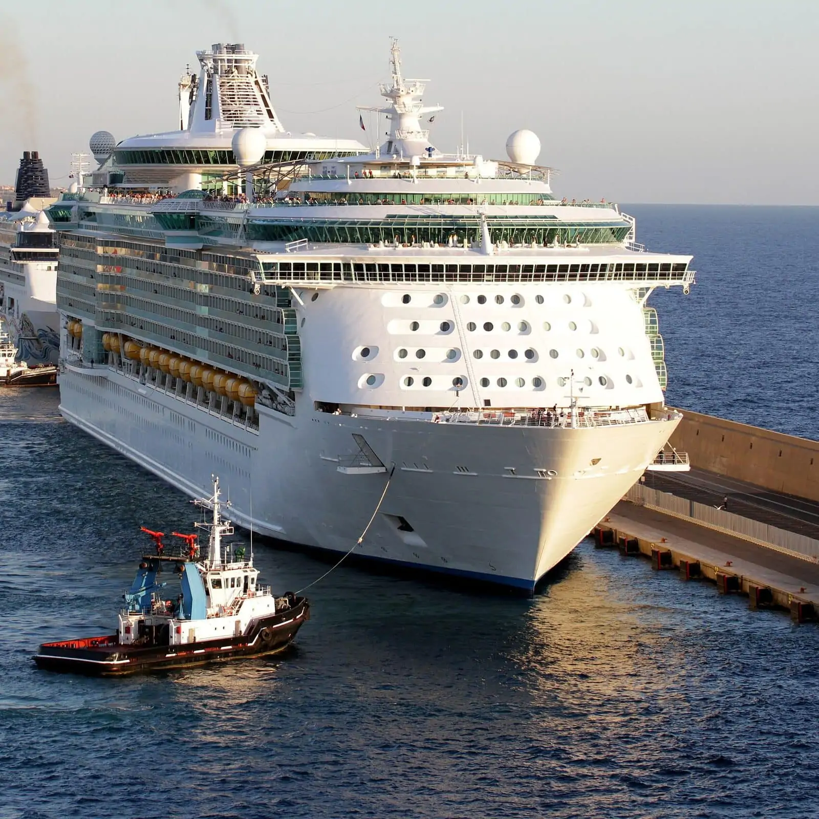 Le navire de croisière Amplified Liberty of the Seas de Royal Caribbean est remorqué par un bateau à cuve